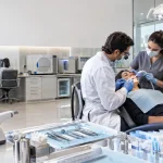 Dentista em clínica odontológica moderna representa a redução de 60% do IBS e da CBS prevista para serviços odontológicos na Reforma Tributária