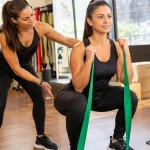 Profissional de educação física orienta exercício em academia, ilustrando redução de 30% no IBS e na CBS