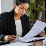 Empresária analisa documentos tributários sobre parcelamento de dívidas e retorno ao Simples Nacional em 2027